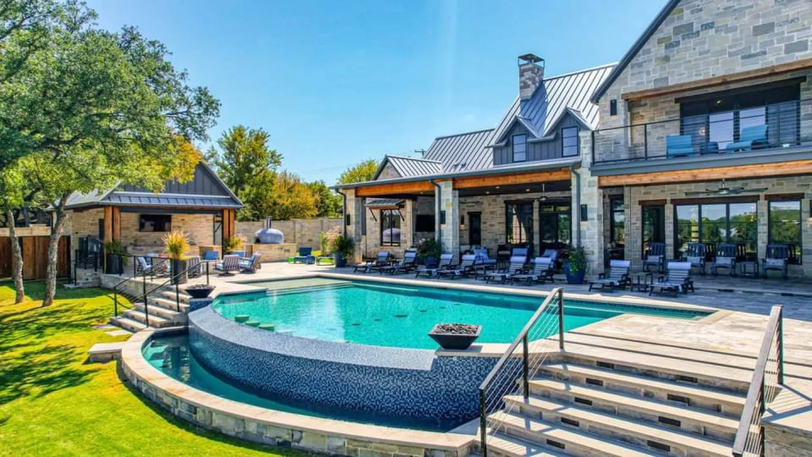 Stone home with a pool and covered patio